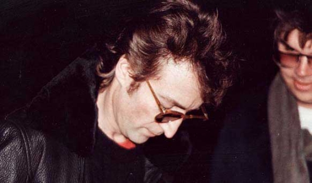 А это Джон Леннон за пару часов до того, как его убьет Марк Дэвид Чэпмэн, человек на фоне.