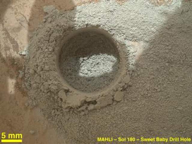 Марсоход Curiousity просверлил отверстие в поверхности Марса, чтобы взять образцы грунта, 4 февраля 2013 года. Диаметр отверстия - около 1,6 см. 