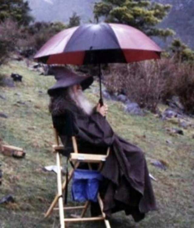 Трилогия Властелин Колец Гэндальф (Сэр Иэн Мюррей Маккелен) с зонтиком в перерыве между дублями. 